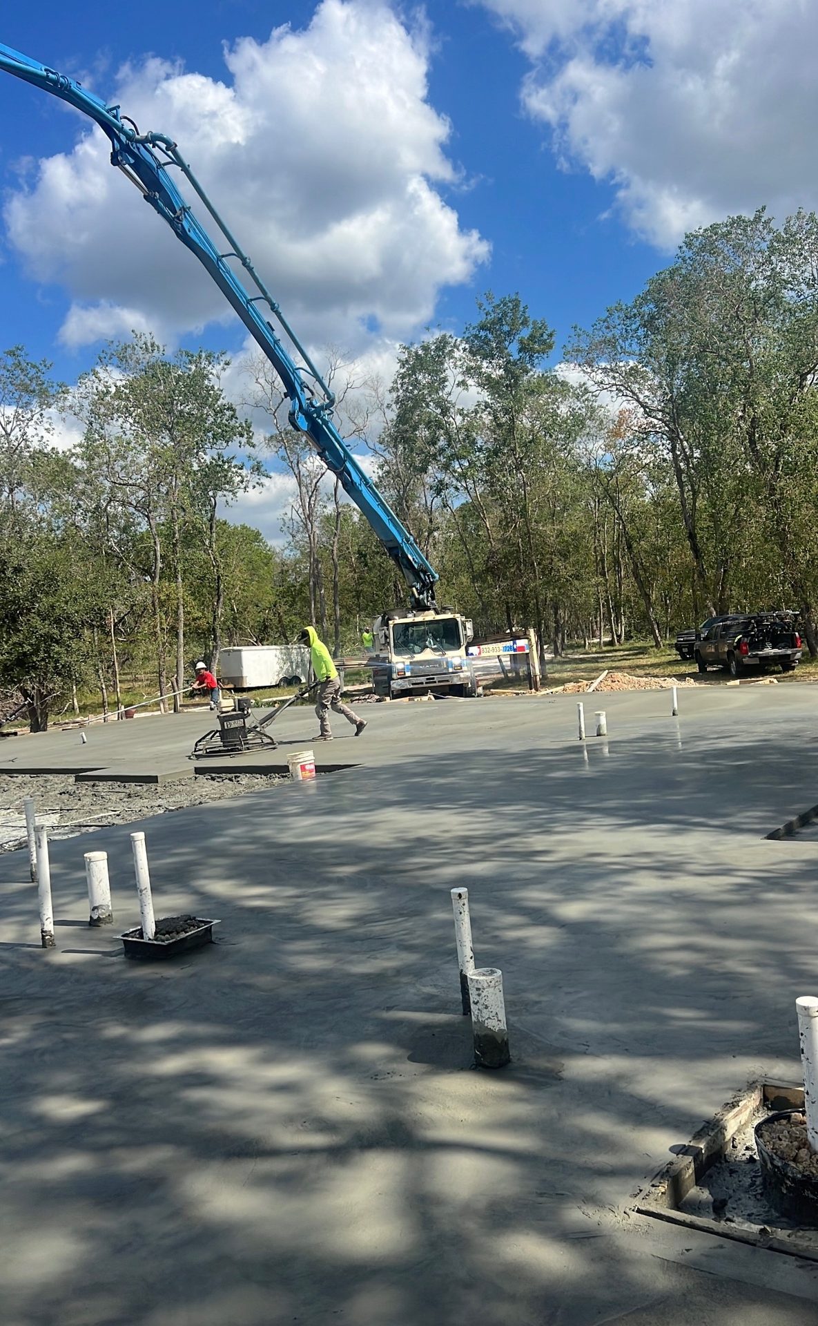 Pump truck placing and finishing a large concrete slab