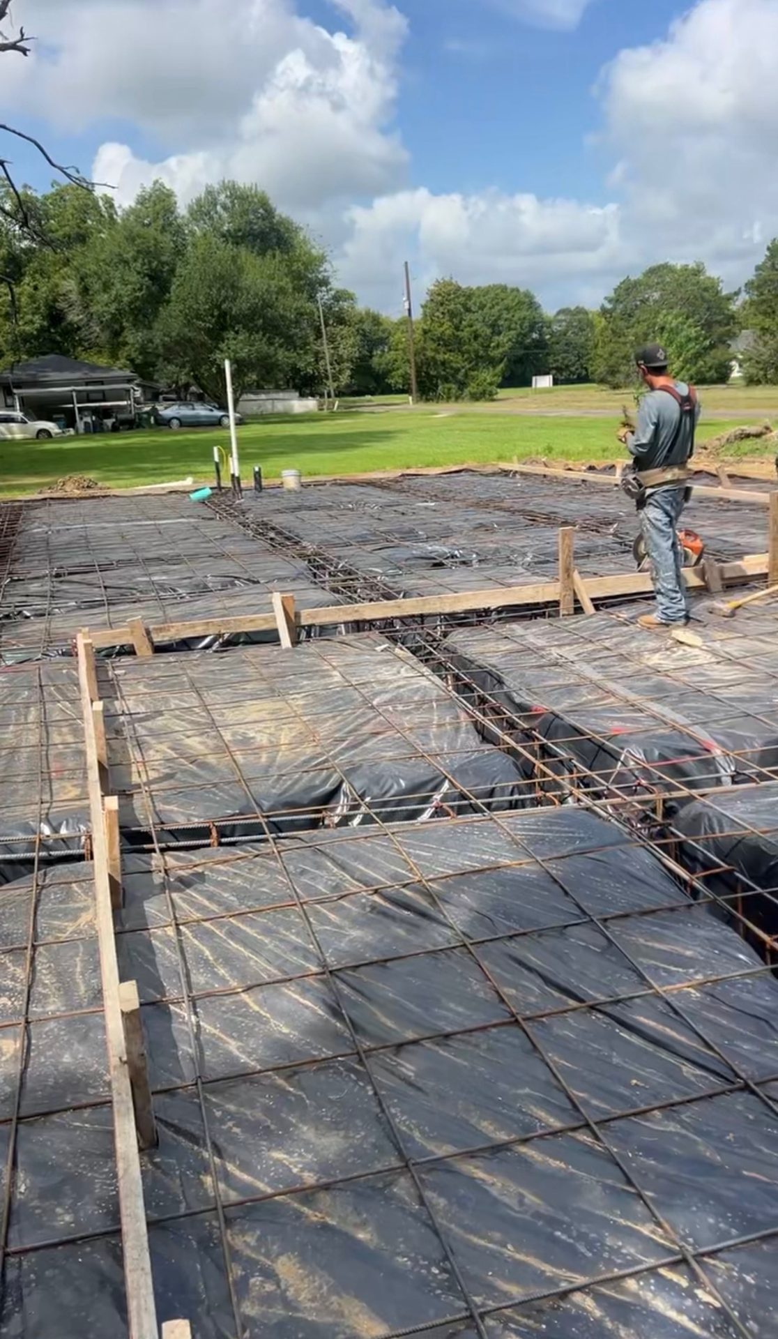 Construction Cowboys crew inspecting rebar and site prep ahead of a pour