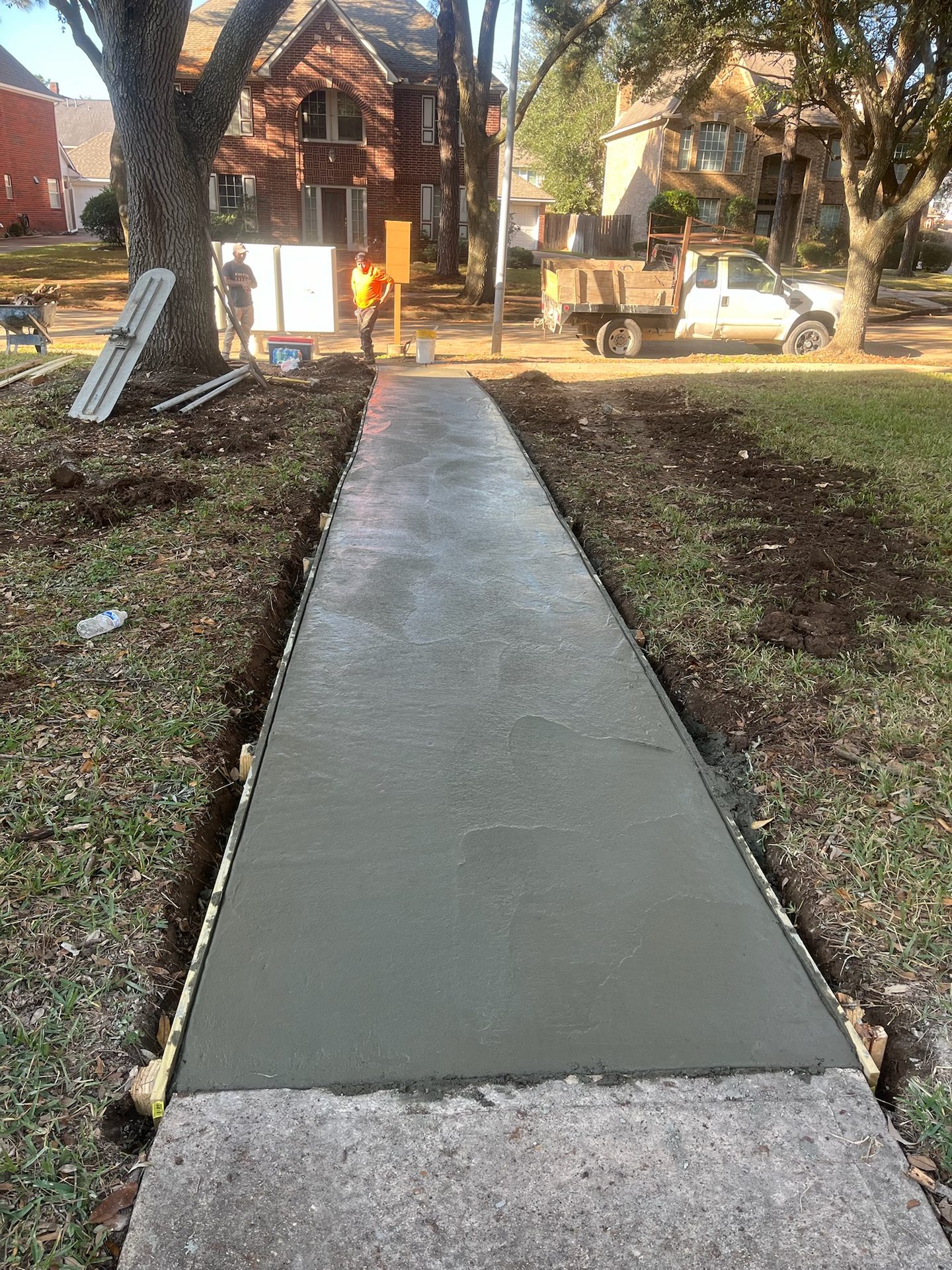 Freshly finished Construction Cowboys sidewalk pour leading to a Houston-area home